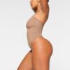 Nahtloser, trägerloser String-Body mit formgebender Silhouette Nahtloser, trägerloser String-Body mit formgebender Silhouette
